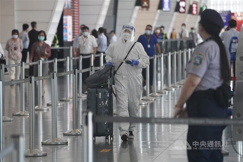 教育部21日宣布開放3類境外生專案入境。圖為機場旅客穿著防護衣,推著行李依動線前往篩檢。(中央社檔案照片)