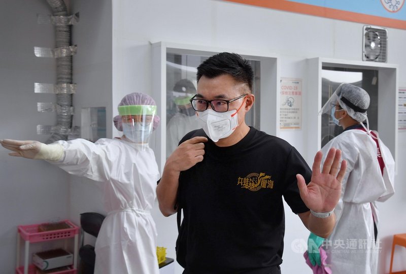 國民黨主席江啟臣(前)22日穿上印有海龍蛙兵的衣服,在台北松山機場做完快篩採檢後,準備搭機前往金門參加八二三砲戰紀念活動。中央社記者王飛華攝 110年8月22日