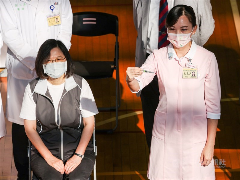 國產高端疫苗23日開始施打,總統蔡英文(左)一早前往台大醫學院體育館,依照相關流程,報到、醫師問診、接種疫苗。圖為護理師在施打前舉起針筒,讓現場媒體拍攝。中央社記者鄭清元攝 110年8月23日