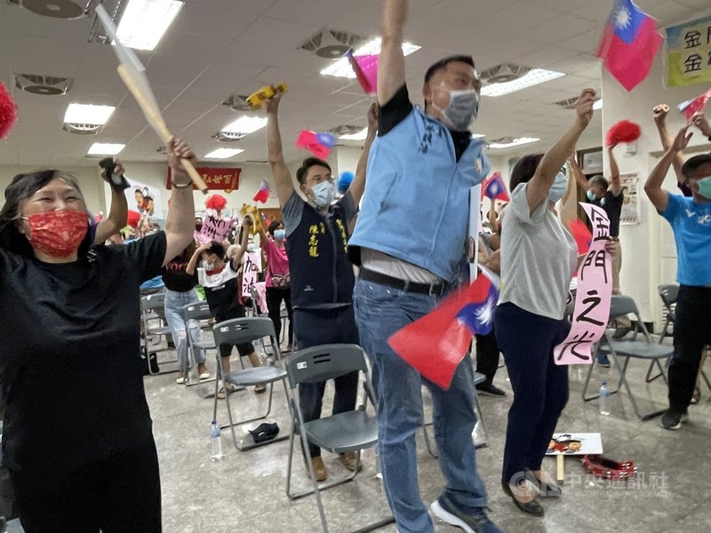 金門酒廠公司宣布,30日將抽出3萬6000盒「麟洋配台灣之光陳年金門高粱酒」給金門縣民,羽球男雙好手李洋和王齊麟都將出席見證。圖為7月31日「麟洋配」奪東京奧運金牌時刻,眾人高舉雙手歡呼。中央社記者黃慧敏攝 110年8月23日