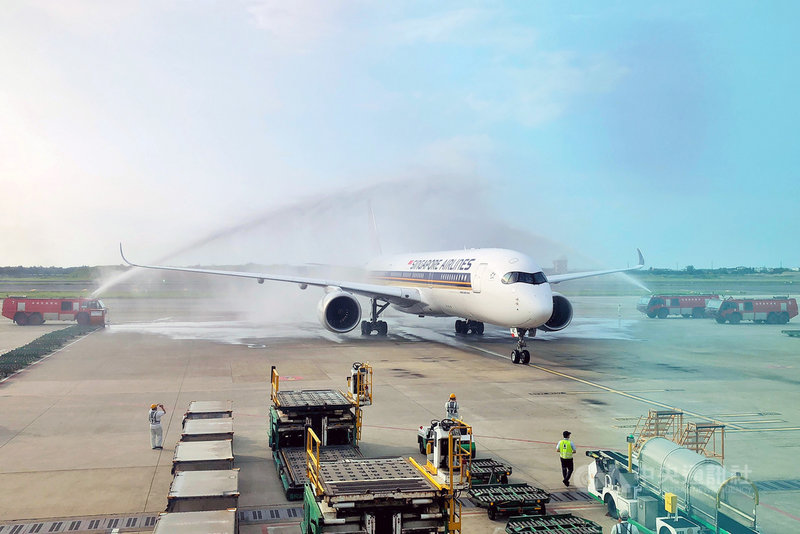 新加坡航空睽違13年復飛台北往返洛杉磯航線,班機25 日下午抵達桃園國際機場時並舉行灑水迎機儀式,現場許多工作人員圍觀。中央社記者吳睿騏桃園機場攝 110年8月25日