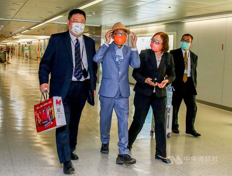 駐泰國代表李應元(左2)26日晚間抵達桃園國際機場,他穿著白襯衫、藍灰色西裝與圍巾,一旁的大使夫人看見記者拍照,特別拿下原本自己戴的帽子給李應元戴上,還不忘叮嚀「你戴帽子比較好看」,鶼鰈情深溢於言表。中央社記者吳睿騏桃園機場攝 110年8月26日