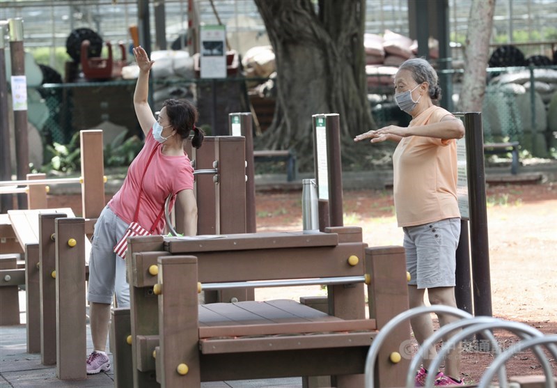 台灣26日新增2例本土COVID-19確診、2例死亡個案。圖為民眾到公園運動,全程配戴口罩並維持社交距離。(中央社檔案照片)