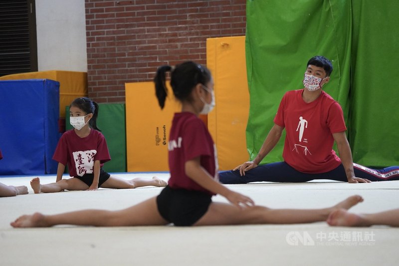 國立台灣師範大學成立小師大體操隊、小大師體操俱樂部,盼培育國內更多體操選手。體操好手唐嘉鴻(後右)27日到台師大體操教室,帶領小師大體操隊學生拉筋熱身。中央社記者徐肇昌攝 110年8月27日