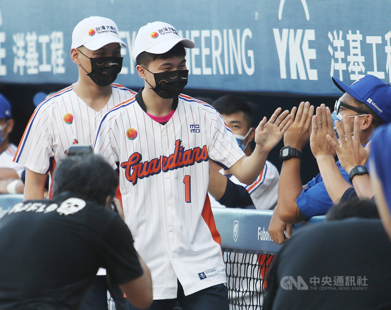 中職富邦悍將隊舉辦主題日「台灣大哥大XVIII悍將中學」,28日並邀請桌球好手林昀儒(白衣前)擔任開球嘉賓,林昀儒開球後與悍將選手擊掌致意。中央社記者張新偉攝 110年8月28日