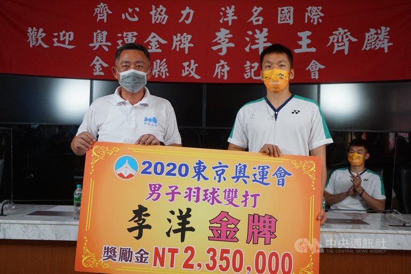 為金門奪得首面奧運金牌的李洋(前右)29日返回家鄉金門,縣長楊鎮浯(前左)致贈李洋奪金獎勵金新台幣235萬元。中央社記者黃慧敏攝 110年8月29日