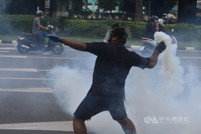 泰國抗議團體「 衝破瓦斯」（Thalugaz）29日在前往總理帕拉育宿舍的鈴丹路口和警方發生激烈衝突，抗議者撿起警方發射的催淚瓦斯丟回去。中央社記者呂欣憓曼谷攝 110年8月29日