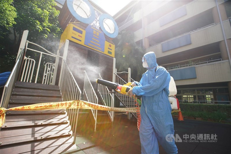 國內29日新增23例確診個案，其中13例為本土病例，另10例為境外移入。圖為清消人員在國小內消毒。中央社記者徐肇昌攝　110年8月29日