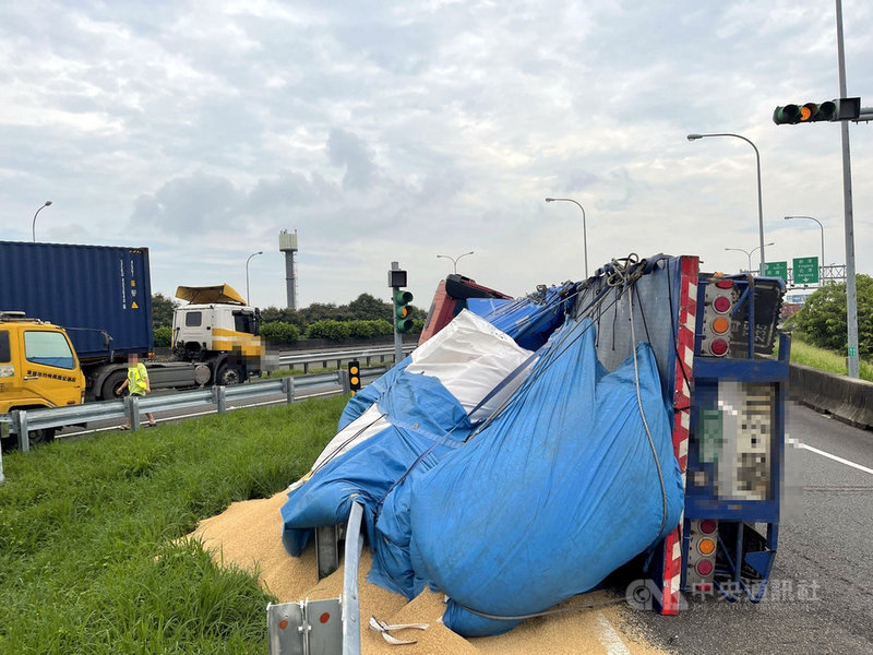 國道1號嘉義交流道入口環道30日發生一輛載運稻穀的聯結車翻覆意外,車上所載運的稻穀散落在邊坡上,所幸駕駛沒有受傷。(國道第四公路警察大隊提供)中央社記者黃國芳傳真 110年8月30日
