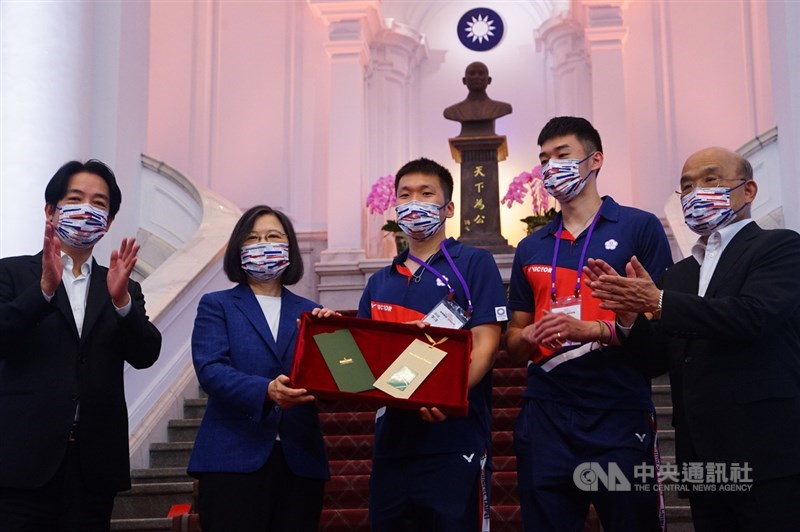 總統蔡英文(左2)、副總統賴清德(左)及行政院長蘇貞昌(右)1日下午接見2020東京奧運代表團,歡迎他們凱旋歸國,蔡總統會中並致贈紀念禮品給羽球男雙金牌組合李洋(中)、王齊麟(右2)。中央社記者王騰毅攝 110年9月1日