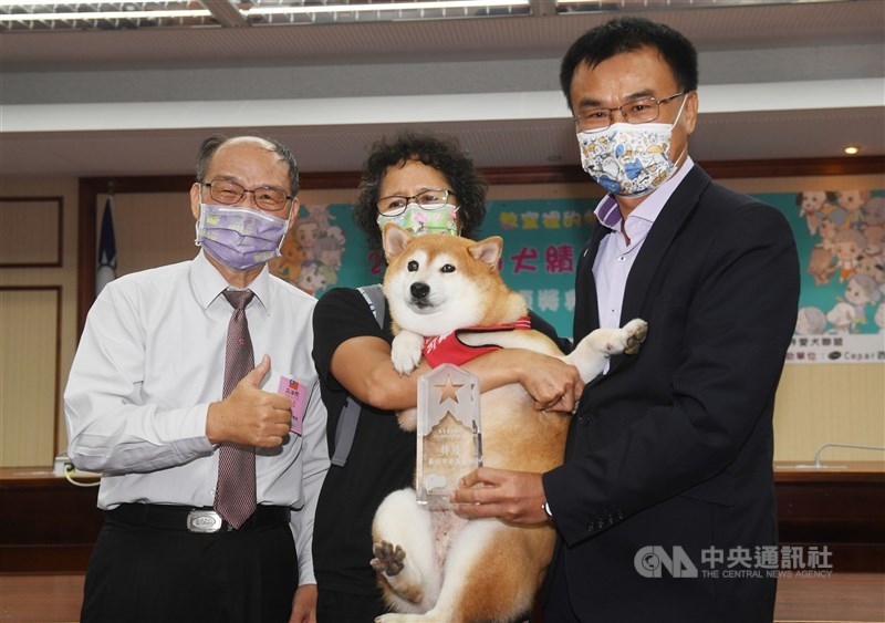 農委會主委陳吉仲(右)3日在立法院出席「教室裡的牠們」校園犬績優學校選拔頒獎典禮,頒優等獎給一起合影。中央社記者施宗暉攝 110年9月3日