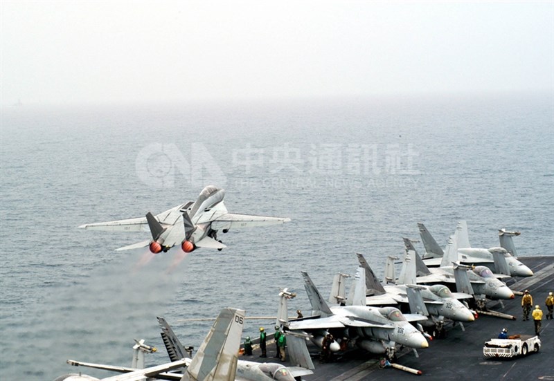 2003年3月美國與伊拉克爆發波斯灣戰爭,圖為一架F-14戰機從位在波斯灣的小鷹號航空母艦升空,前往轟炸伊拉克目標,而甲板上還有許多其他戰機在待命發動攻擊。(中央社檔案照片)