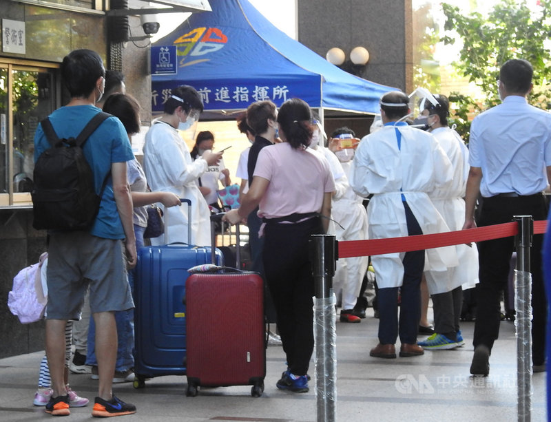 新北市長侯友宜8日表示,新北幼兒園染疫基因定序為Delta變異株,板橋某社區大樓B棟清空集中檢疫400人,採逐戶通知隔離住戶,也由板橋區公所進駐成立前進指揮所。圖為社區居民帶行李在中庭等待專車接送。中央社記者王鴻國攝 110年9月8日