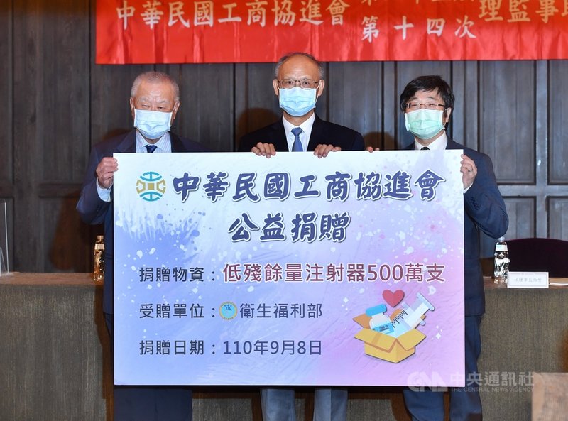 工商協進會8日召開「第25屆第14次理監事聯席會議」,會中捐出5百萬支「低殘餘量注射器」給衛生福利部,由疾管署長周志浩(右)代表受贈。左為工商協進會理事長林伯豐,中為行政院政務委員鄧振中。中央社記者王飛華攝 110年9月8日