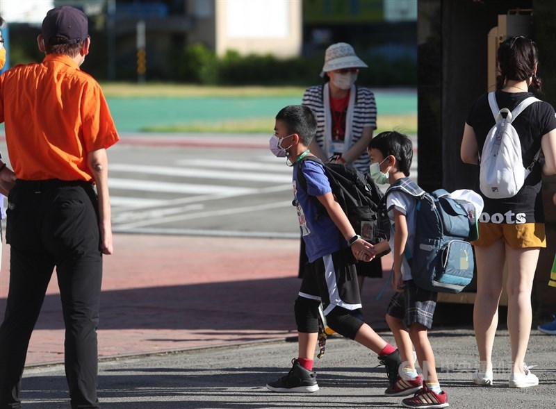 新北市幼兒園群聚案延燒,因應Delta病毒入侵,新北多所學校預防性停課,以建立防火牆,確保師生健康。圖為板橋區一所國小10日恢復上課,小朋友手牽手進校園。中央社記者吳家昇攝 110年9月10日