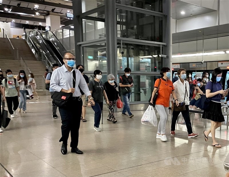 新加坡政府10日宣布,下週起將調整密切接觸者的隔離天數,由14天縮短至10天。圖為新加坡民眾戴口罩搭地鐵。(中央社檔案照片)