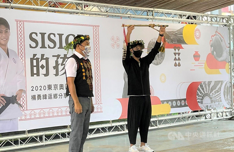 在東京奧運勇奪柔道銀牌的「柔道男神」楊勇緯(右)11日與家人返回屏東縣獅子鄉南世村分享經驗,楊勇緯並獲鄉長周英傑(左)致贈勇士之刀。(莊瑞雄服務處提供)中央社記者郭芷瑄傳真 110年9月11日
