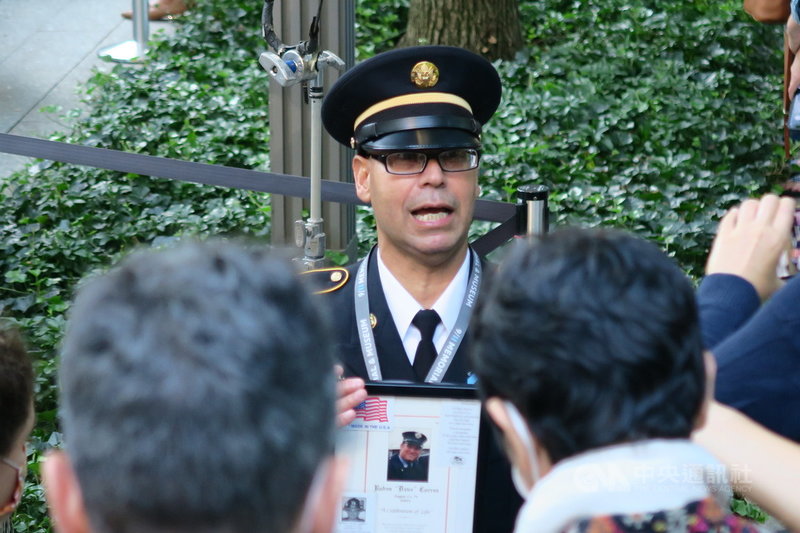 退役美軍中士莫拉萊斯捧著在911事件中罹難的表哥照片,出席在紐約世界貿易中心雙塔遺址舉行的20週年追悼儀式。中央社記者尹俊傑紐約攝 110年9月12日