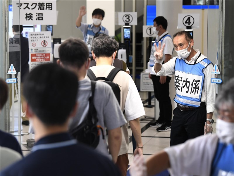 日本境內COVID-19疫情漸趨緩,專家指出疫苗接種是原因之一。圖為青少年在大阪大規模接種中心等待施打疫苗。(共同社)