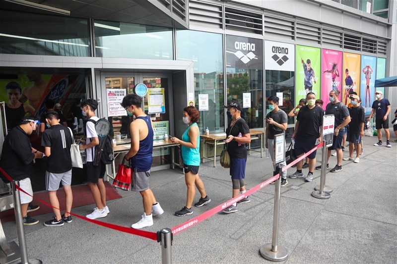 指揮中心指揮官陳時中表示,20日後疫情警戒不降級,但會鬆綁防疫規定,包括鬆綁大型場所容留人數限制。圖為民眾排隊進運動中心。(中央社檔案照片)