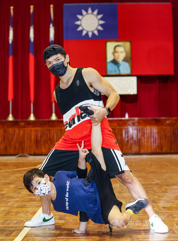110年國慶表演團體「TBC舞團」15日在台北警專大禮堂為演出練習,舞者之一的邱仕惠(後)與年僅6歲的「納納」(前)合作呈現高難度地板動作。中央社記者鄭清元攝 110年9月15日
