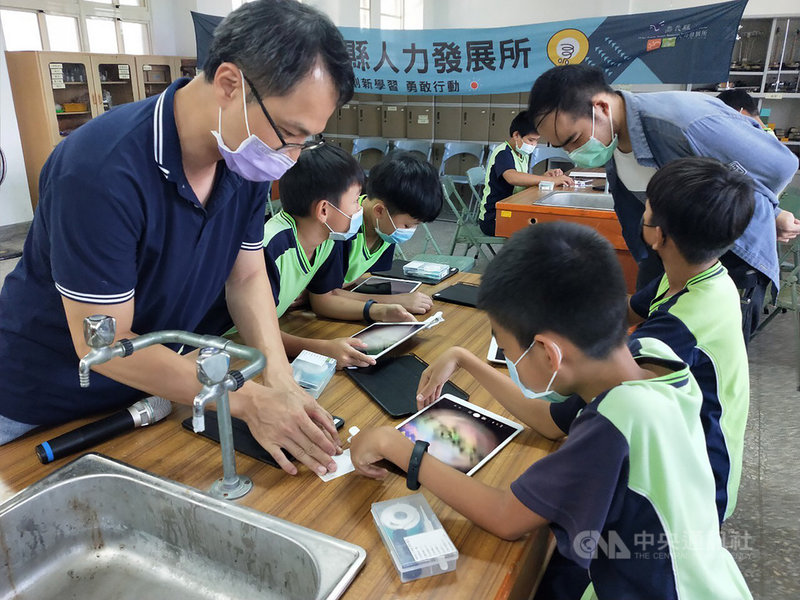 嘉義縣大埔國民中小學16日引進「微觀實驗、裝備實驗室」課程,不需要用傳統的顯微鏡,只要拿著平板裝上顯微鏡頭,就能觀察物件的細微之處。台大博士林建明(左)指導學生使用「行動顯微鏡」。(嘉義縣政府提供)中央社記者蔡智明傳真 110年9月16日