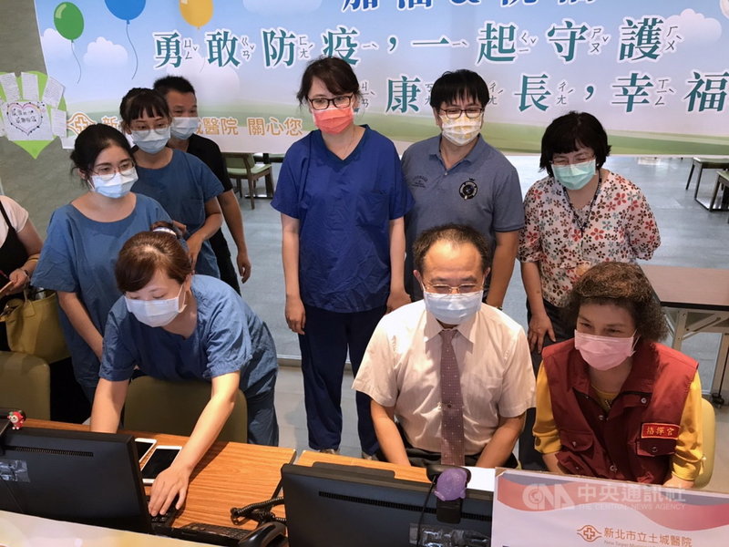 新北市立土城醫院長黃璟隆(前右2)與萬里區長粘雪琴(前右1)17日以視訊方式與野柳集中檢疫中心住民提前歡慶中秋,給予隔離民眾關懷。(土城醫院提供)中央社記者黃旭昇新北傳真 110年9月17日