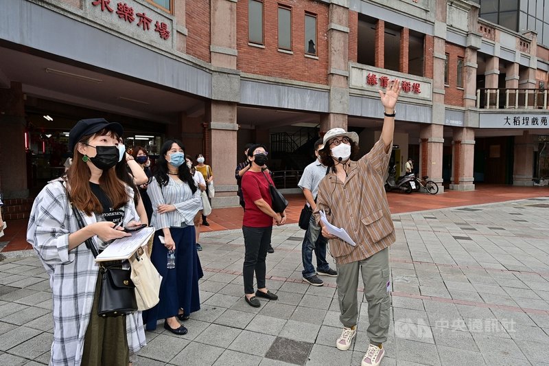文化部辦理「走讀台灣」活動,由社會學家李明璁(右)規劃4條路線,結合「文本」與「文化路徑」多元閱讀體驗,邀請民眾行腳台灣,閱讀在地。圖為李明璁為民眾解說大稻埕永樂市場的歷史與風華。(文化部提供)中央社記者邱祖胤傳真 110年9月17日