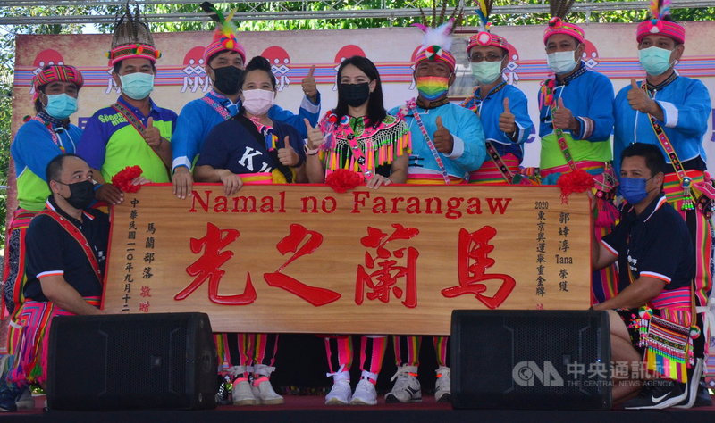 「舉重女神」郭婞淳(中)18日穿著阿美族傳統服飾回到部落,部落特別製作「馬蘭之光」木匾,由郭家長輩送給郭婞淳。中央社記者盧太城台東攝 110年9月18日
