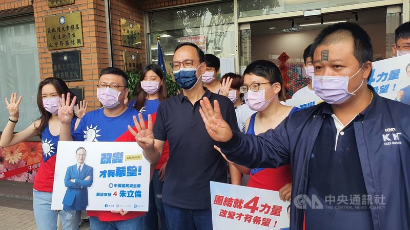 國民黨主席選舉政見會高屏場18日舉行,候選人朱立倫(前中)會後與穿著國旗裝的年輕支持者熱情合影,共同比出「4號」手勢。中央社記者洪學廣攝 110年9月18日
