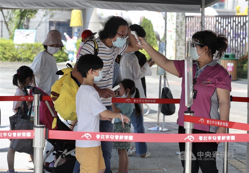 中秋連假第2天,台北市兒童新樂園19日湧現人潮,為落實防疫規定,工作人員在遊客進場前實施量測體溫等。中央社記者張皓安攝 110年9月19日