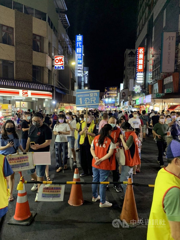 中秋節連續假期第3天,嘉義市文化路夜市20日晚間湧入滿滿人潮,嘉義市政府人員在夜市各路口進行管制及舉牌宣導,提醒民眾做好防疫措施。(嘉義市政府提供)中央社記者黃國芳傳真 110年9月20日