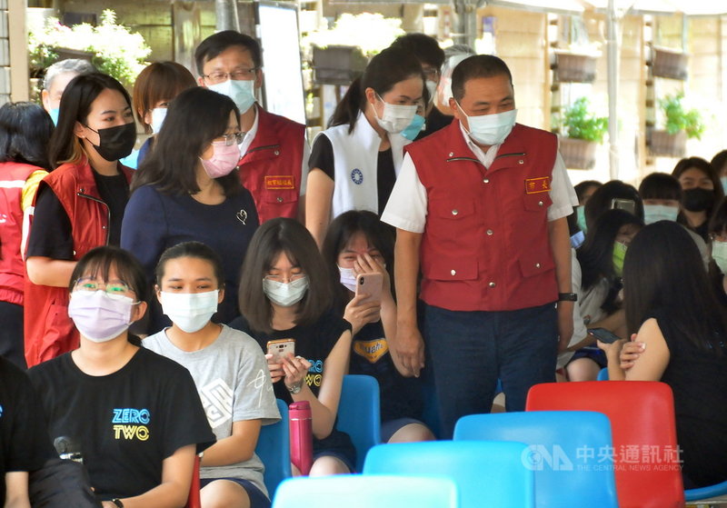 新北市長侯友宜(後右)22日下午到板橋高中視察學生疫苗接種情形,在休息觀察區提醒學生要多喝水。中央社記者黃旭昇新北攝 110年9月22日
