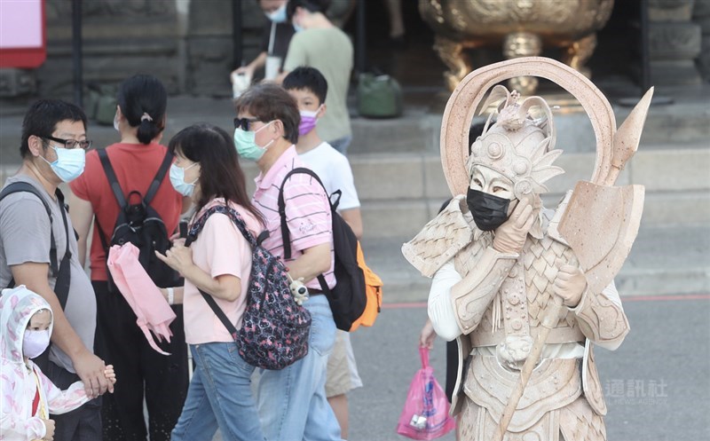 截至台灣22日上午7時,全球至少470萬6641人病逝於COVID-19,至少2億2946萬2218人確診。圖為街頭藝人戴上口罩表演。(中央社檔案照片)