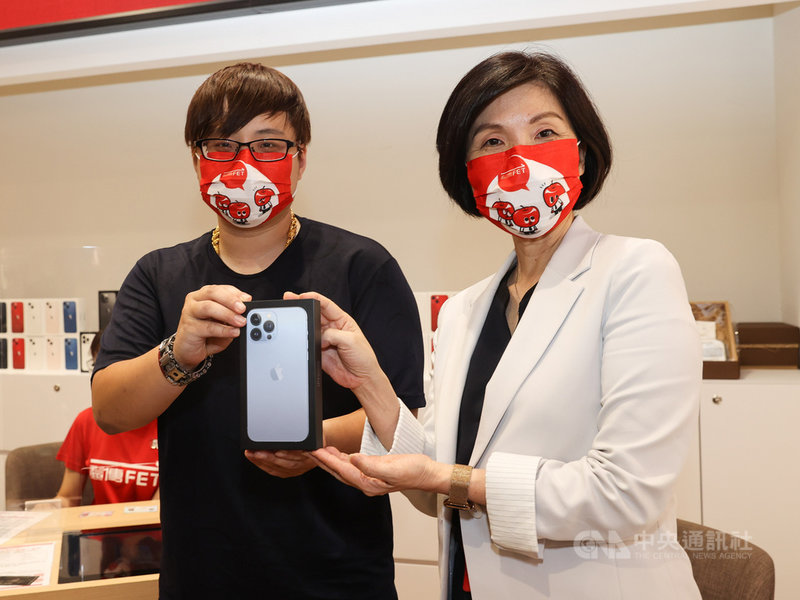 蘋果iPhone 13系列新機24日開賣,電信三雄照例於信義威秀門市舉辦首賣,搶到遠傳電信頭香的民眾劉先生(左)拿到新機後,與遠傳電信總經理井琪(右)合影留念。中央社記者鄭清元攝 110年9月24日