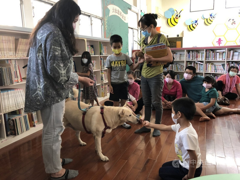 高雄市動物保護處訓練來自收容所的流浪犬,25日上午汪星人化身「伴讀書僮」,到圖書館陪伴孩童閱讀。(高雄市動保處提供)中央社記者蔡孟妤傳真 110年9月25日