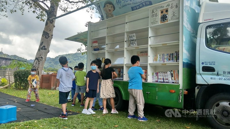 「雲水書坊-行動圖書館」前進新北偏鄉石碇區和平國小,全校學生沉浸於豐富藏書,在藍天白雲樹下享受閱讀樂趣。(校方提供)中央社記者黃旭昇新北傳真 110年9月25日