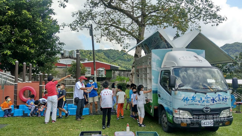 「雲水書坊-行動圖書館」前進新北偏鄉石碇區和平國小,由貨車改裝的「海鷗書車」擺放豐富藏書,孩子們挑選自己喜歡的書籍,在樹蔭下或溜滑梯旁坐下來閱讀。(校方提供)中央社記者黃旭昇新北傳真 110年9月25日