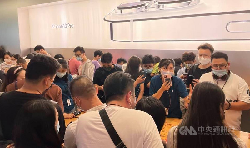 蘋果全新的iPhone 13系列上週上市,引發搶購熱潮,上海多家蘋果直營店滿滿排隊與選購人潮。圖為上海一間蘋果直營店內,工作人員正在向消費者介紹iPhone 13系列手機。中央社記者吳柏緯上海攝 110年9月26日