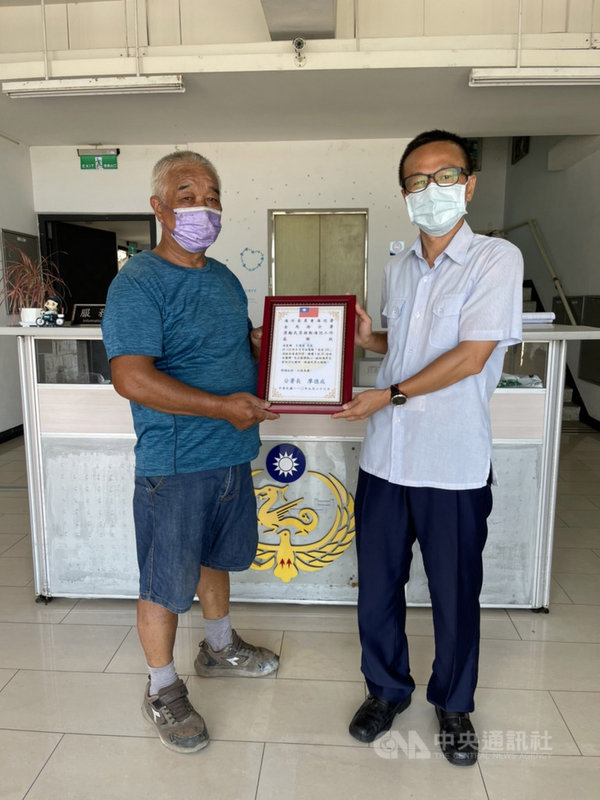 連江縣南竿鄉漁民王連進(左)出港捕魚作業時,意外撈到1枚未爆彈,進港後主動通報山隴執檢站,協助相關單位到場處置,解除馬祖海上環境風險,26日獲海巡表揚為優良漁民。(第十岸巡隊提供)中央社記者邱筠馬祖傳真 110年9月26日
