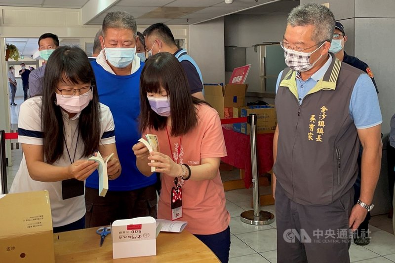 金門限定的3000元振興券已完成驗收,27日點交給各鄉鎮公所,金沙鎮公所人員實際清點確切數量,確認無誤後領回。右為金沙鎮長吳有家。中央社記者黃慧敏攝 110年9月27日
