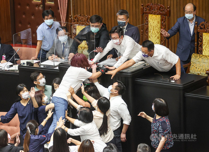 立法院院會28日上午在藍綠激烈衝突下,議事停擺,下午宣布繼續開會,國民黨立法院黨團書記長陳玉珍(中白衣藍褲者)趁黨團總召費鴻泰質詢時突襲主席台,遭民進黨立委群起阻擋。中央社記者鄭清元攝 110年9月28日