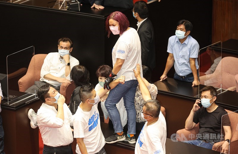 立法院會28日繼續邀請行政院長蘇貞昌進行施政報告並備質詢,開議前國民黨立委陳玉珍(中)突襲官員席,站在桌上,一旁的民進黨立委鄭運鵬(後左)則一臉無奈。中央社記者鄭清元攝 110年9月28日