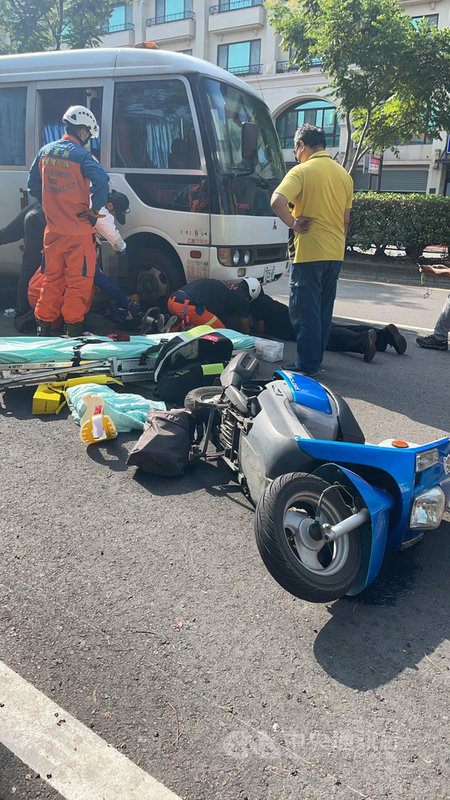 苗栗市國華路29日發生中型巴士與機車碰撞事故,女騎士被捲入中巴車底,消防救難人員趕往搶救,動用破壞器材,協助女騎士脫困送醫;中型巴士駕駛(黃衣男子)聲稱意外發生前並沒有看到機車。(民眾提供)中央社記者管瑞平傳真 110年9月29日