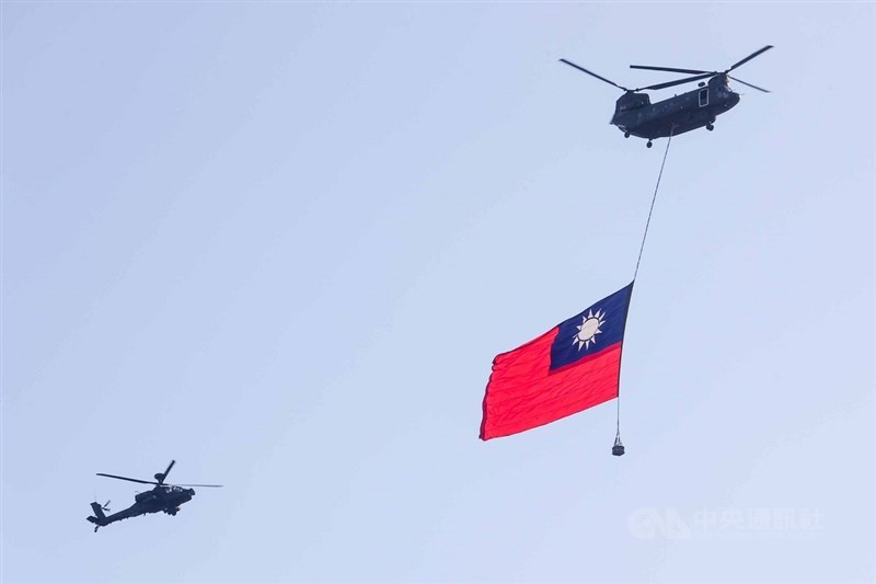 國軍30日舉行空中全兵力預演,空軍CH-47運輸直升機吊掛巨幅國旗,在AH-64E阿帕契直升機伴飛下通過台北上空。中央社記者王騰毅攝 110年9月30日
