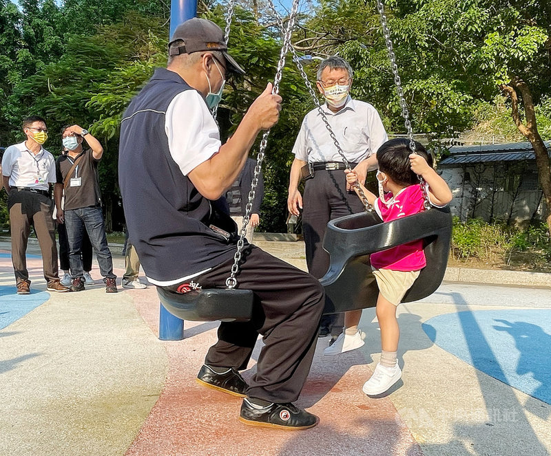 台北市長柯文哲(後右)1日下午前往象山公園,視察公園兒童遊戲場(遊具)重新開放首日情形,和盪鞦韆的小朋友互動對話。中央社記者郭日曉攝 110年10月1日