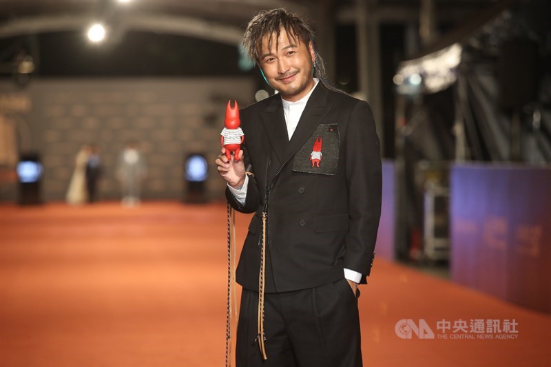 KID林柏昇帥氣登紅毯,服裝及手中公仔皆帶有「小鬼」黃鴻升的象徵。中央社記者張新偉攝 110年10月2日