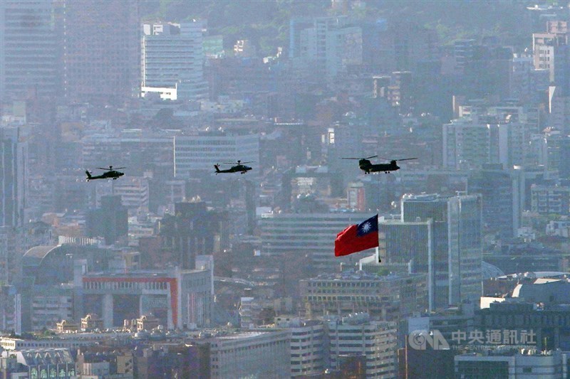 雙十國慶將至,國軍及空勤總隊5日上午6時至7時50分再次進行空中全兵力預演,圖為CH-47直升機吊掛18公尺乘12公尺、史上最巨幅國旗通過台北市上空。中央社記者徐肇昌攝 110年10月5日