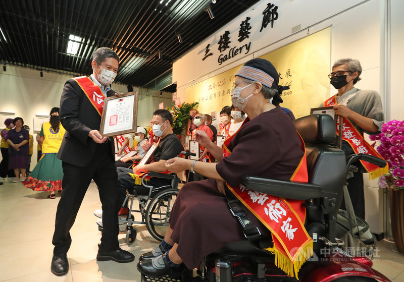 「工藝公益.點亮台灣」第12屆身障者與收容人藝術創作大展記者會7日在中正紀念堂3樓藝廊舉行,文化部長李永得(前左)出席與會,頒發感謝狀給參展的藝術創作者。中央社記者裴禛攝 110年10月7日