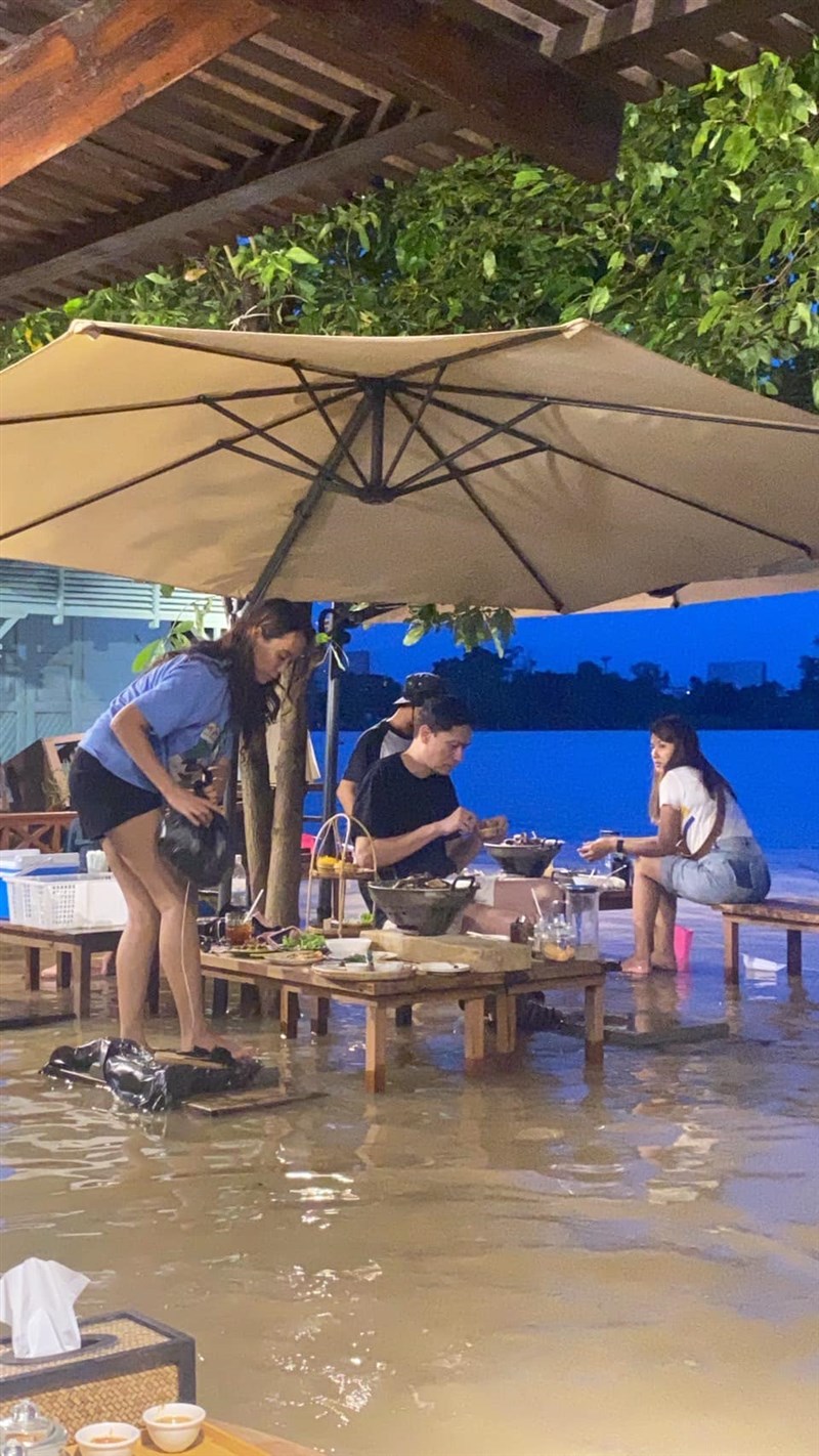 水淹太高時,顧客必須站在椅子上、或是坐在別張桌子上才能吃飯。(圖取自facebook.com/ChaoprayaAntiqueCafe)